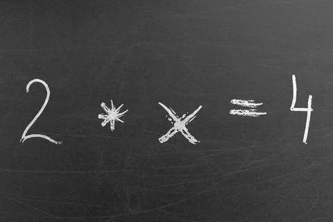 Simple math multiplication equation on the chalkboard in the school Stock Photos
