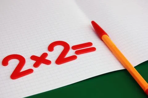 A simple mathematical example in a clean school notebook. Back to school. Stock Photos