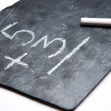 Simple maths on a blackboard with chalk Stock Photos