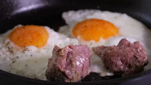Simple men's food - egg with braised chunks of meat fried in a cast iron skil Stock Footage 155882753