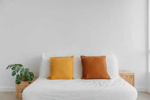 Simple minimal sofa decorated with pillows in white living room. Stock Photos