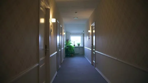 Simple but Nice Small Hotel Hallway. Lightly Lit with Yellow Wall Lamps. Stock Footage 297492597