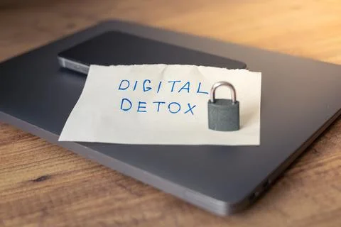 Simple note for digital detox placed on a wooden table with a locked phone Stock Photos