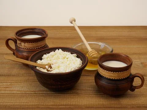 Simple nutritious breakfast with cottage cheese, milk and honey in a crockery on Stock Photos
