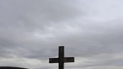 Simple oak catholic cross in focus, moving storm clouds Stock Footage 98446280