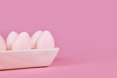 Simple one colored Easter eggs in egg tray on pink background with copy space Stock Photos