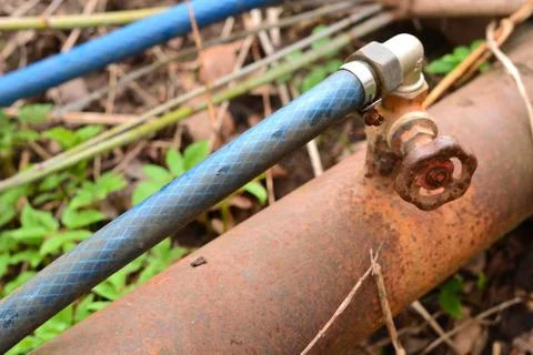Simple photo background composition image of rusty pipe with valve and plasti Stock Photos