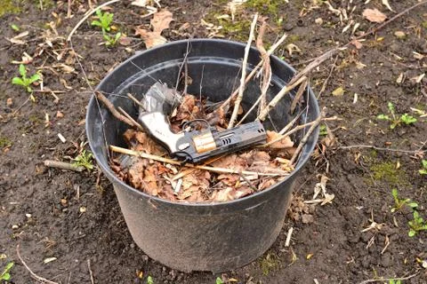 Simple photo background composition image of plastic pistol in pile of trash Stock Photos