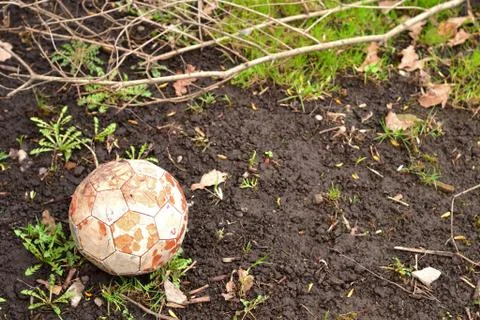 Simple photo background image of old football ball on the ground Stock Photos