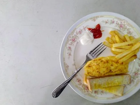 Simple plated breakfast includes omelet, fries, toast, and assorted sauces Pe Stock Photos