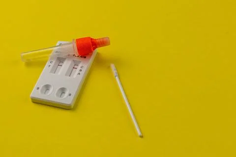 Simple rapid test kit on yellow background ready for use at home Stock Photos