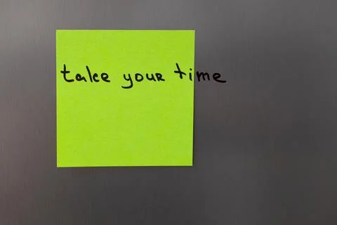 A simple reminder to slow down and relax is written on a neon green sticky no Stock Photos