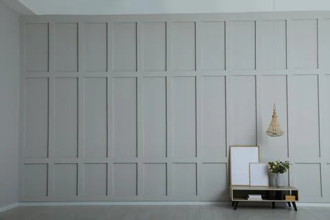 Simple room interior with console table, decor elements and empty wall. Space Stock Photos