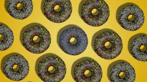 Simple rotation pattern of chocolate glazed donuts on yellow background. Stock Footage 196484789