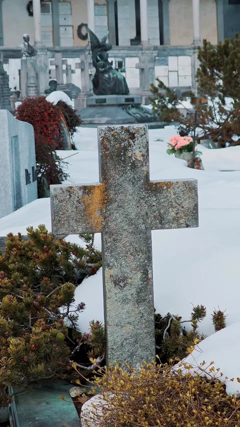 Simple rough stone cross partially covered with snow stands in a serene winter Stock Footage 329309120