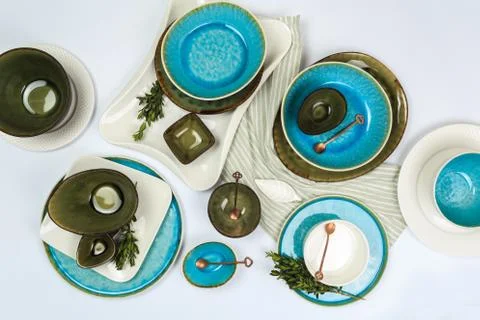 Simple rustic handmade blue and green crockery against white wooden wall: dis Stock Photos