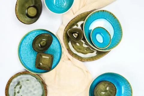 Simple rustic handmade blue and green crockery against white wooden wall: dis Stock Photos