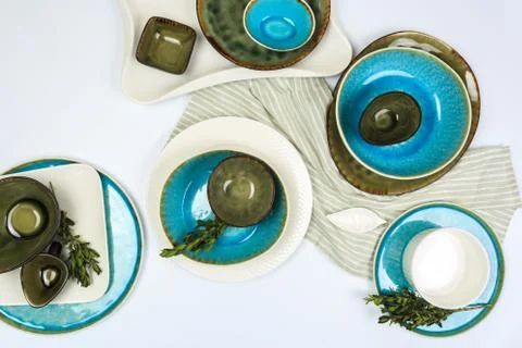Simple rustic handmade blue and green crockery against white wooden wall: dis Stock Photos