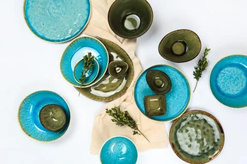 Simple rustic handmade blue and green crockery against white wooden wall: dis Stock Photos