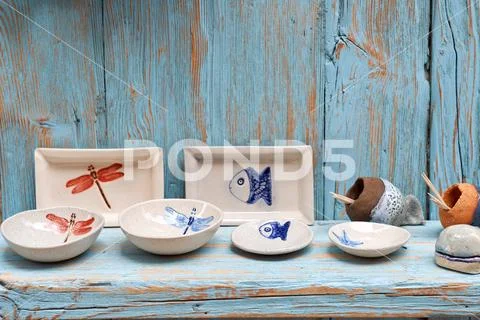 Simple rustic kitchenware against blue wooden wall : Pretty ceramic dishes Stock Photos