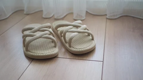 Simple sandals placed by the window on a wooden floor Stock Footage 335191943