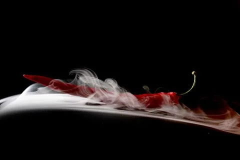 Simple smoke on black background with red hot pepper Foto stock