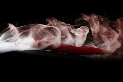 Simple smoke on black background with red hot pepper Foto stock