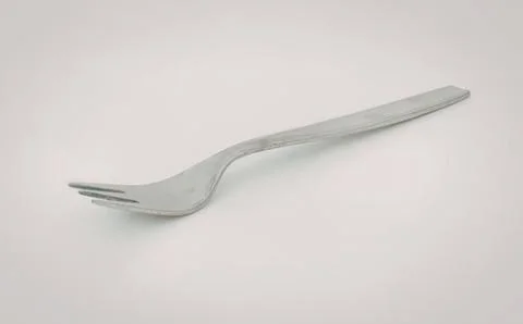 Simple stainless steel fork on plain background Stock Photos