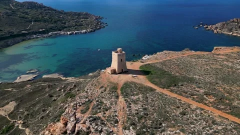 Simple stone tower on top of rock near the sea in Malta, drone fly around 360° Stock Footage 258235770