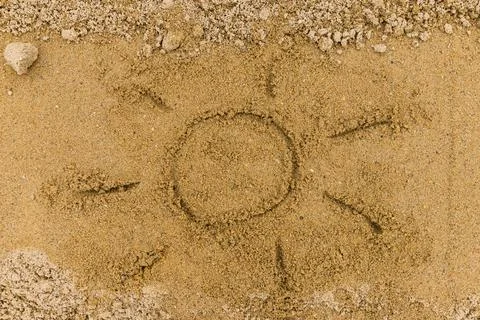 Simple sun drawing in the sand on the beach, room for your copy space Stock-Fotos
