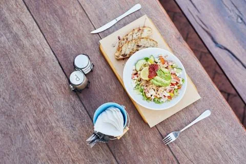 Simple table setting with salad, cutlery, condiments and serviet Stock Photos