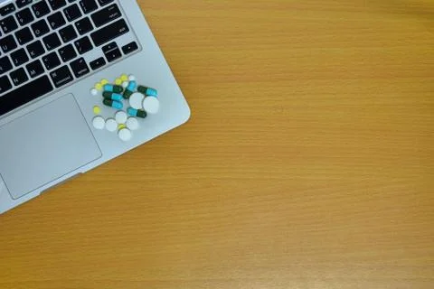 Simple top view of computer have medicine drug pills and tablet on keyboard w Stock Photos