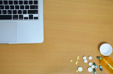 Simple top view of computer with medicine drug pills , bottle and tablet on w Stock Photos