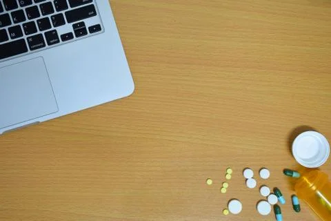 Simple top view of computer with medicine drug pills , bottle and tablet on w Stock Photos