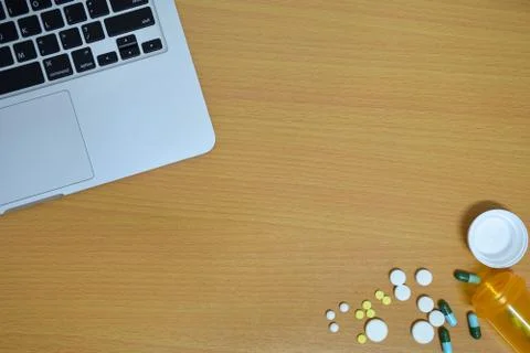 Simple top view of computer with medicine drug pills , bottle and tablet on w Stock Photos