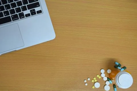Simple top view of computer with medicine drug pills , bottle and tablet on w Stock Photos