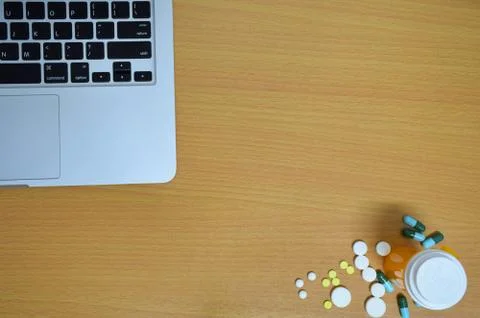 Simple top view of computer with medicine drug pills , bottle and tablet on w Stock Photos