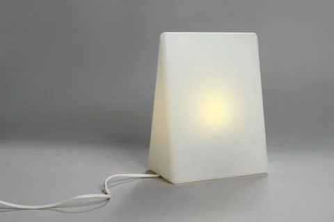 Simple triangular nightlight on a gray surface 스톡 사진