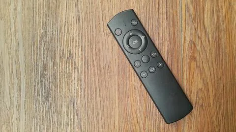 Simple tv remote or remote receiver satellite tv on wooden background Stock Photos