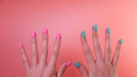 Simple two color gel nail design. Female hands appear on pink background Stock Footage 233576995