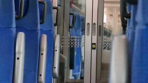 Simple vacant modern passenger train interior, rows of plain blue seats, empty Stock Footage 167372956