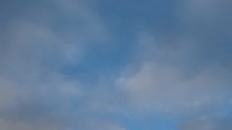 A simple view of white and gray indistinct clouds moving through a light blue sk Stock Footage 144137908