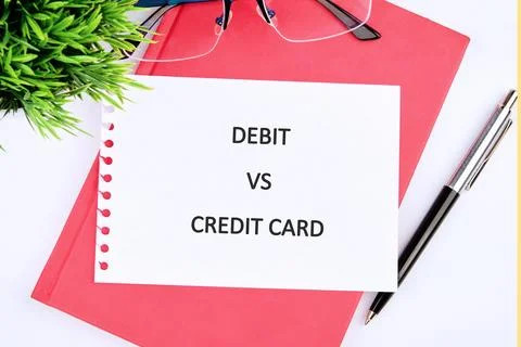 A simple view of a white paper with the words debit vs credit card on a pink  Fotos Stock