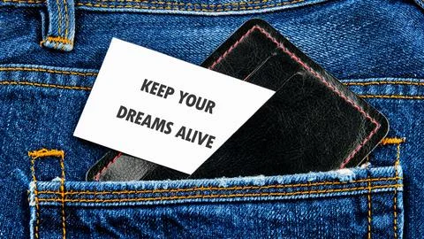 A simple white card with the encouraging message KEEP YOUR DREAMS ALIVE sits in Stock Photos