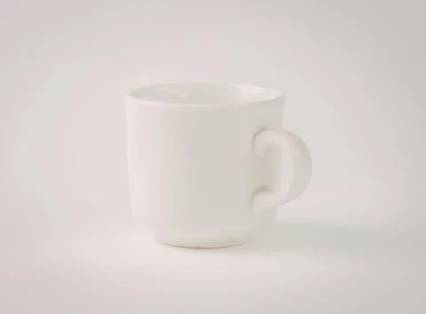 Simple white ceramic coffee mug with handle Photos