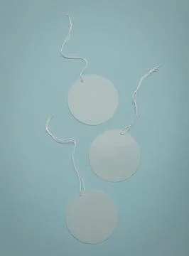 Simple white circular tags with string on blue background Stock Photos
