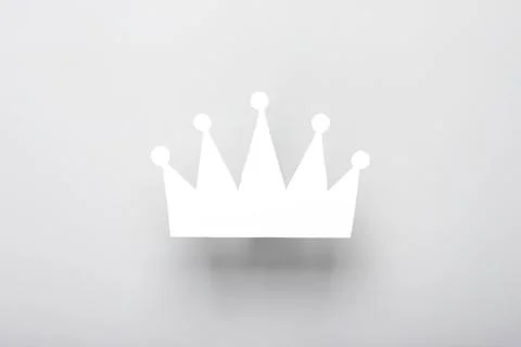 Simple white crown icon on a light gray background Stock Photos