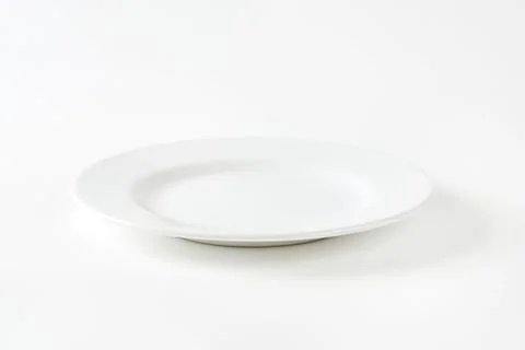 Simple white dinner plate on clean surface Stock Photos