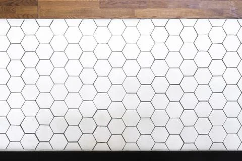 Simple white hexagonal wall tiles and wooden texture pattern of hexagons as a Stock Photos