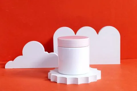 Simple white jar with a pink lid, displayed creatively with cloud-like props and Stock Photos